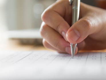 Hand with pen over application form