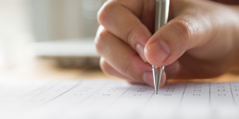 Hand with pen over application form